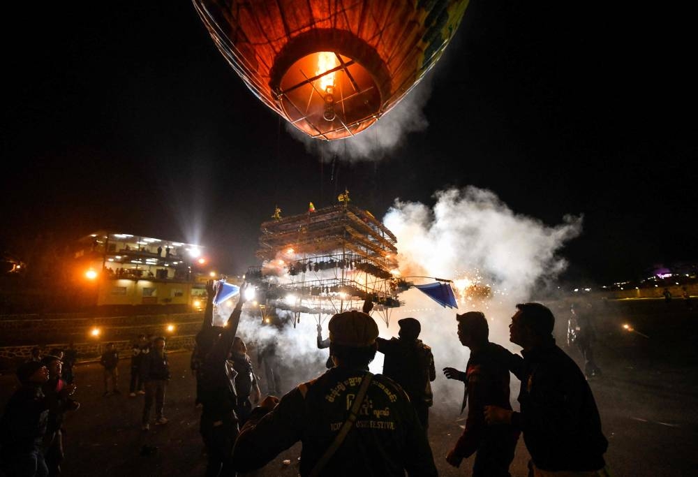 This photo taken on November 6, 2022 shows revellers releasing a hot-air balloon attached with fireworks during the Tazaungdaing Lighting Festival at Pyin Oo Lwin Township in Mandalay. — AFP pic