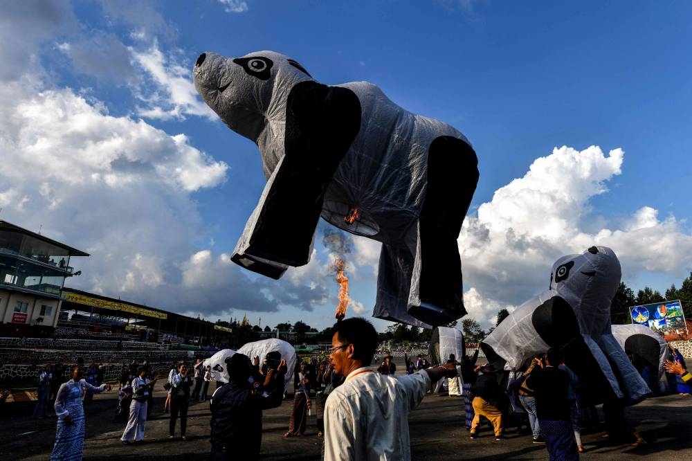 This photo taken on November 6, 2022 shows revellers preparing to release a polar bear shaped hot-air balloon during the Tazaungdaing Lighting Festival at Pyin Oo Lwin Township in Mandalay. — AFP pic