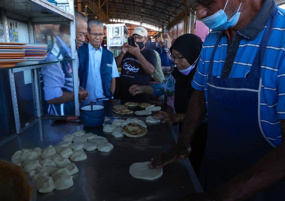 Tan Sri Muhyiddin Yassin greets traders during a walkabout at the Jitra Market in Kedah November 8, 2022. — Bernama pic