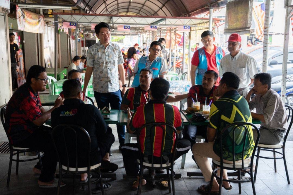 Simon Ooi meets a group of Malay voters during one of his walkabouts in Alor Setar.