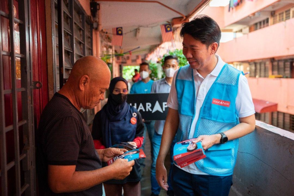 Simon handing out PH pamphlets to residents of Rumah Pangsa Simpang Kuala.