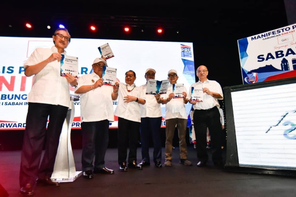 GRS leaders hold up the coalition’s 15th general election manifesto at the Sabah International Convention Centre in Kota Kinabalu on Nov 8, 2022. — Picture by Julia Chan