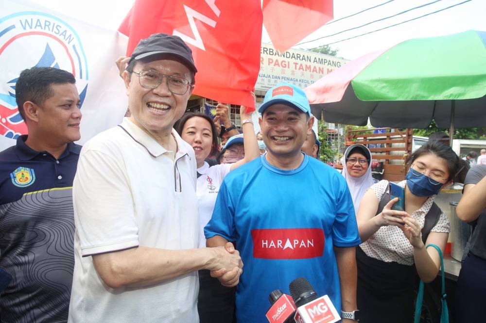 Pandan candidates Rafizi Ramli (right) and Ong Tee Keat shake hands during their walkabout at the Taman Muda wet market November 6, 2022. — Pictures by Choo Choy May