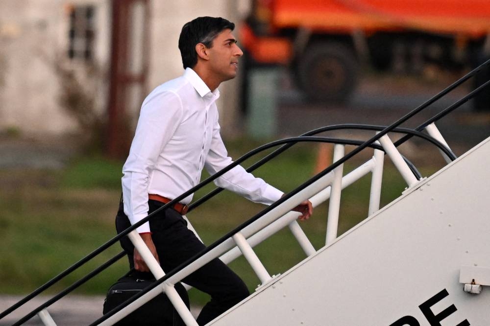 British Prime Minister Rishi Sunak boards a plane to travel to G20 meeting in Bali at Stanstead airport, London November 13, 2022. — Reuters pic