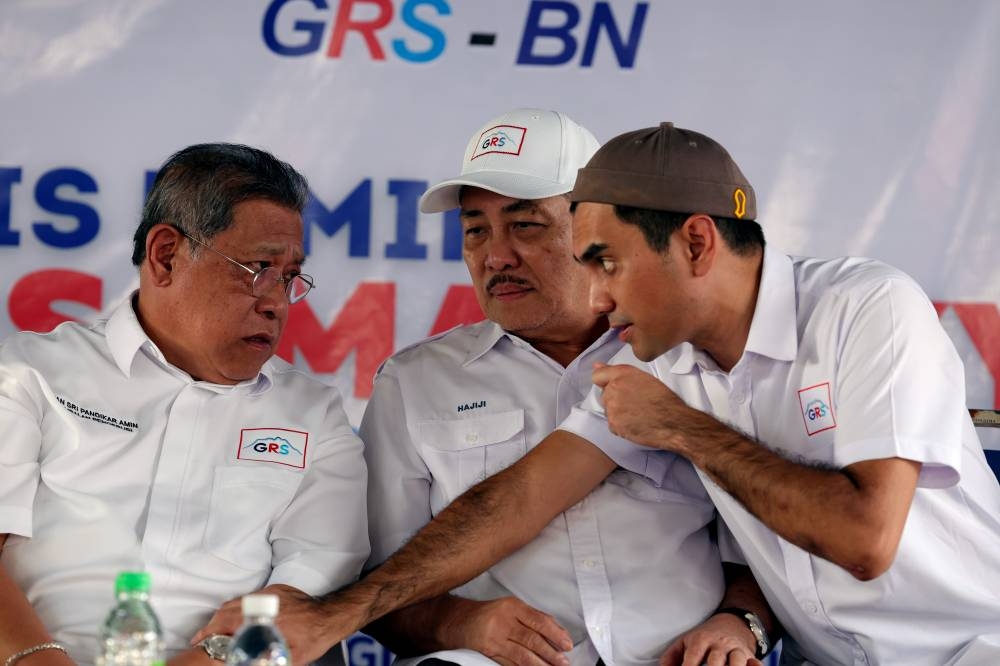 GRS chairman and Sabah Chief Minister Datuk Hajiji Noor (centre) listens to Batu Sapi candidate Khairul Firdaus Akbar Khan (right) at a meet-and-greet event with the people of Libaran at the Gum Gum People’s Housing Project in Sandakan November 16, 2022. — Bernama pic