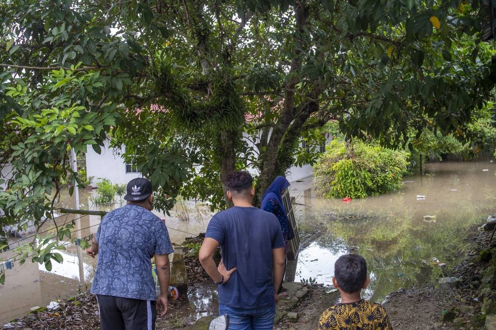 Villagers survey the water damage at their homes in Kampung Lahar Yooi. — Picture by Shafwan Zaidon