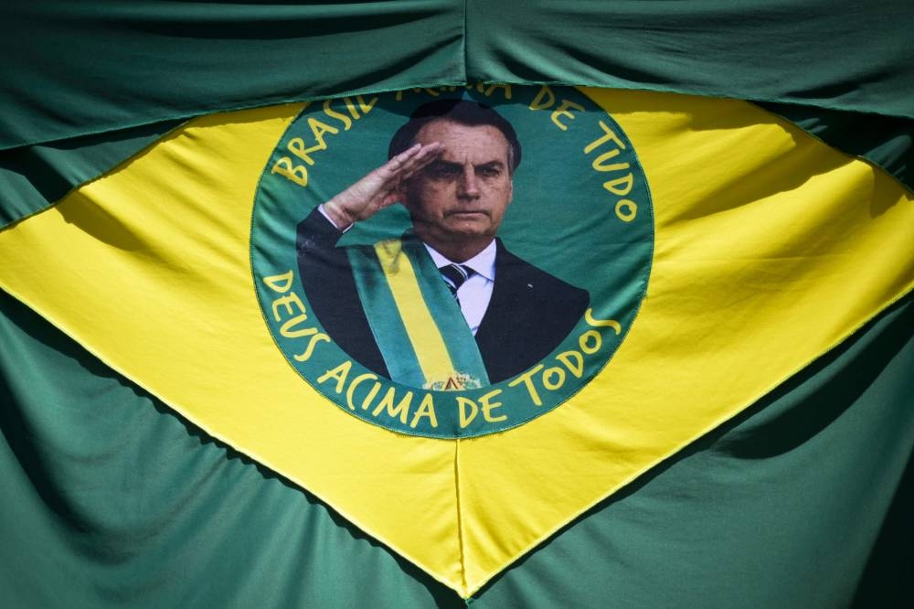 In this file photo taken on October 12, 2022, a Brazilian flag with the face of Brazil's President Jair Bolsonaro hangs on the street in Belo Horizonte, Brazil. ― AFP file pic