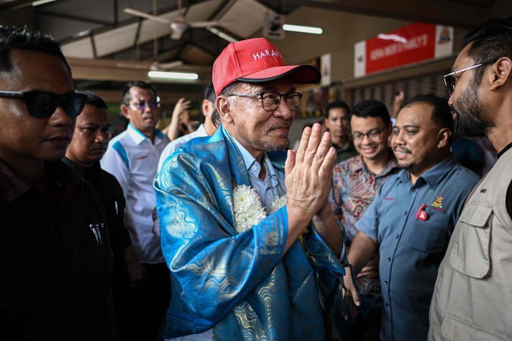 Datuk Seri Anwar Ibrahim gestures as he arrives at a campaign rally ahead of the country's general elections in Kuala Lumpur November 16, 2022. — AFP pic