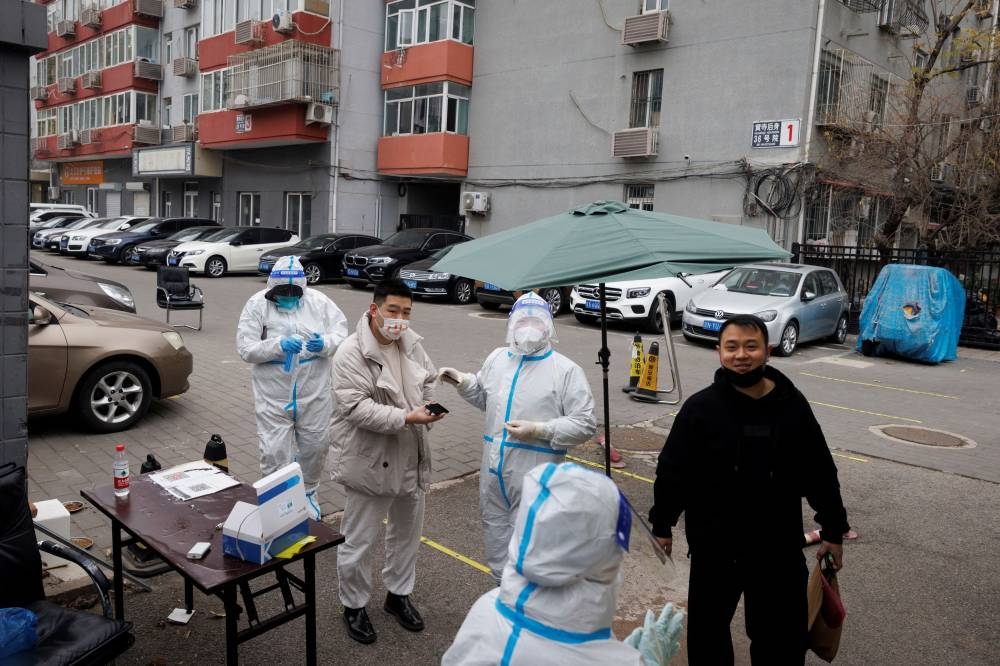 Residents arrive to get a swab test at a testing station inside a locked-down residential compound as outbreaks of the coronavirus disease continue in Beijing, China November 18, 2022. — Reuters pic