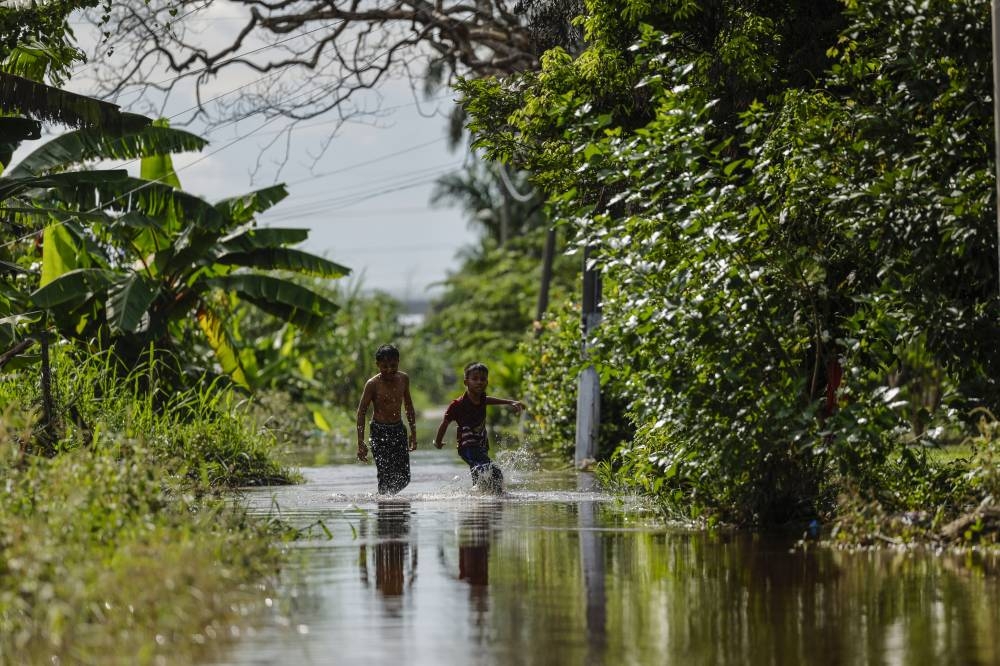 Children are seen playing in receding floodwaters in Kampung Johan Setia, Klang November 17, 2022. — Bernama pic