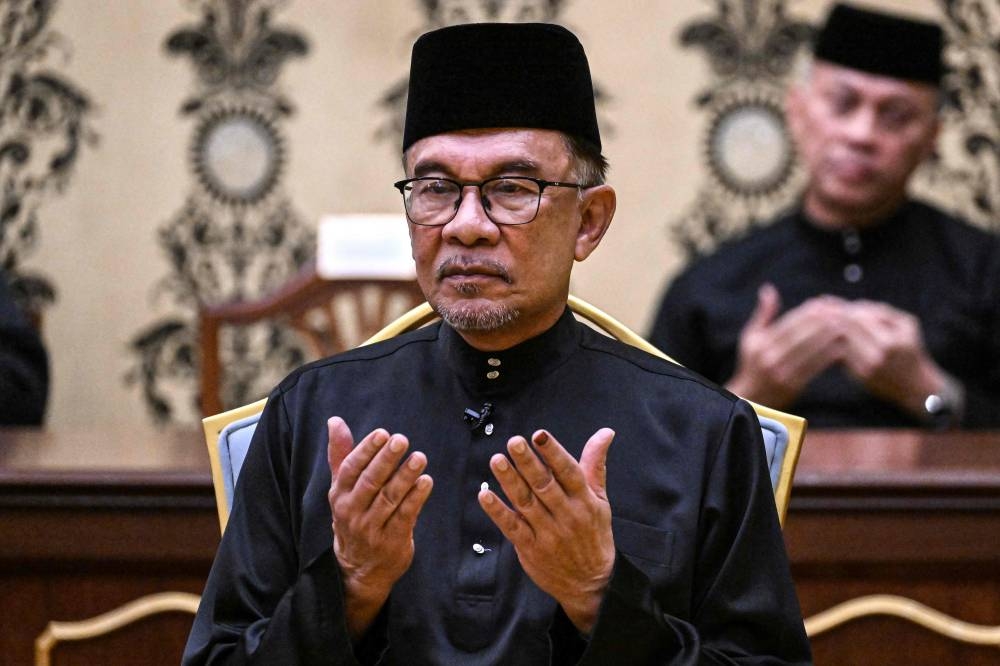 Malaysia’s newly appointed Prime Minister Datuk Seri Anwar Ibrahim offers prayers after taking the oath during the swearing-in ceremony at the National Palace in Kuala Lumpur, November 24, 2022. — AFP pic 