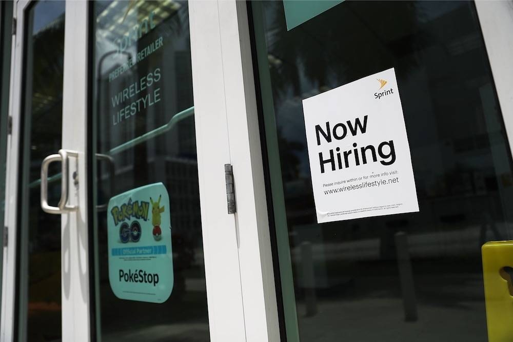 This file photo taken on July 7, 2017 shows a now hiring sign in a window of a business in Miami. The unemployment rate in Sabah has dropped to 8.2 per cent or 174,200 people in the third quarter of this year. — AFP pic