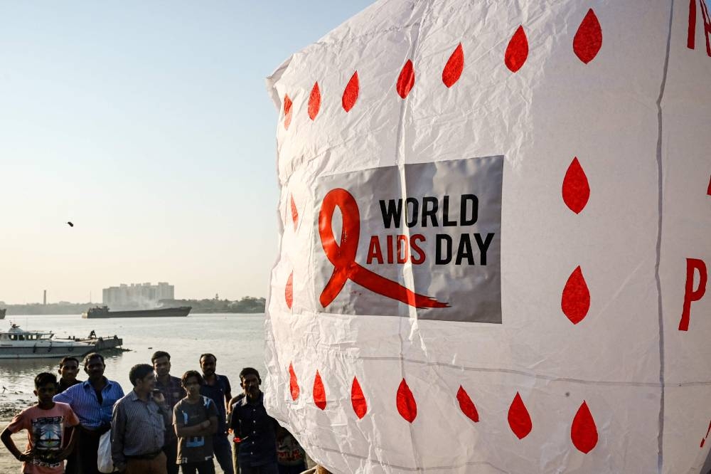 Social activists prepare to release a traditional hot air balloon to create awareness about HIV AIDS on the eve of ‘World AIDS Day’ in Kolkata on November 30, 2022. — AFP pic