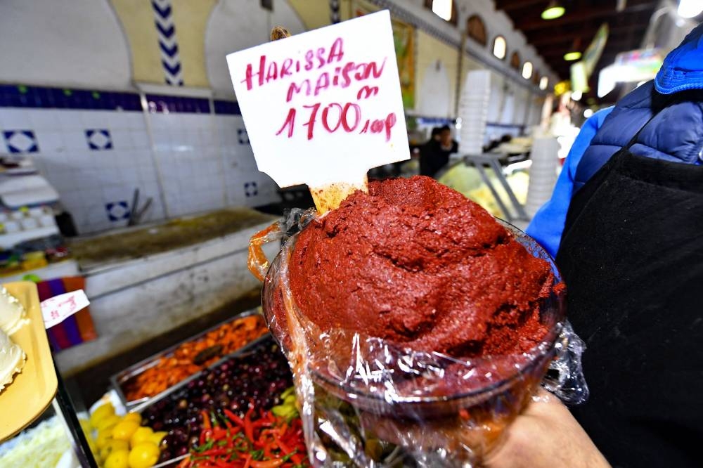 A shopkeeper shows a plate of Tunisian Harissa at the central market of the capital Tunis on December 1, 2022. — AFP pic