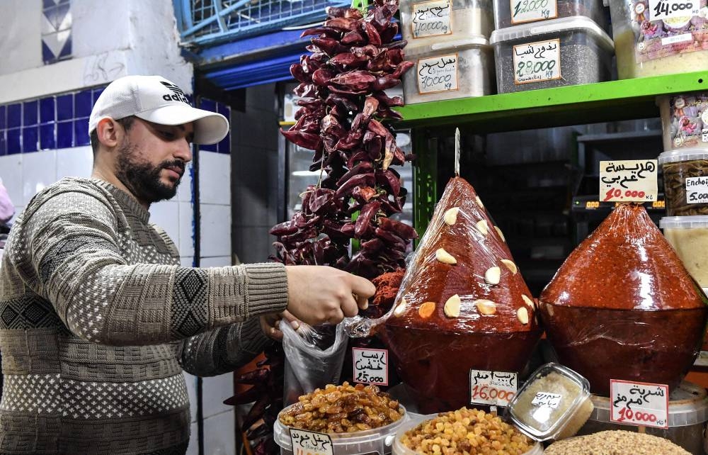 A shopkeeper scoops Tunisian Harissa to serve customers at the central market of the capital Tunis on December 1, 2022. — AFP pic