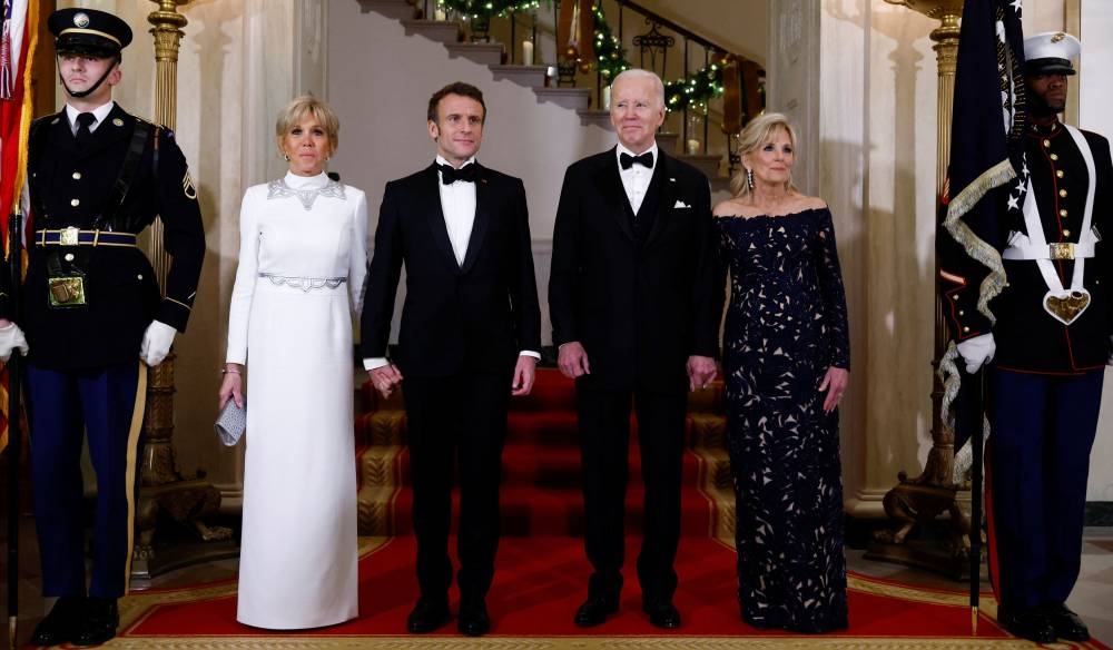 US President Joe Biden, US first lady Jill Biden, France's President Emmanuel Macron and his wife Brigitte Macron pose for a picture at the Grand Staircase of the White House on the occasion of the State Dinner, in Washington December 1, 2022. — Reuters pic