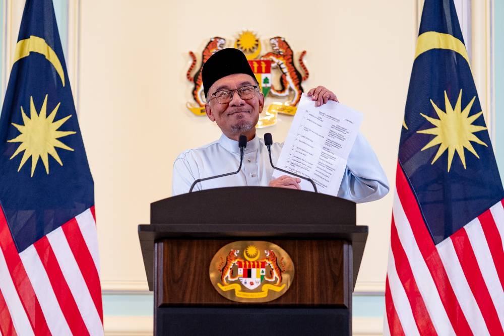 Prime Minister Datuk Seri Anwar Ibrahim shows the list of his Cabinet line-up during a live telecast, December 2, 2022. — Handout pic by Sadiq Asyraf/Prime Minister’s Office of Malaysia 