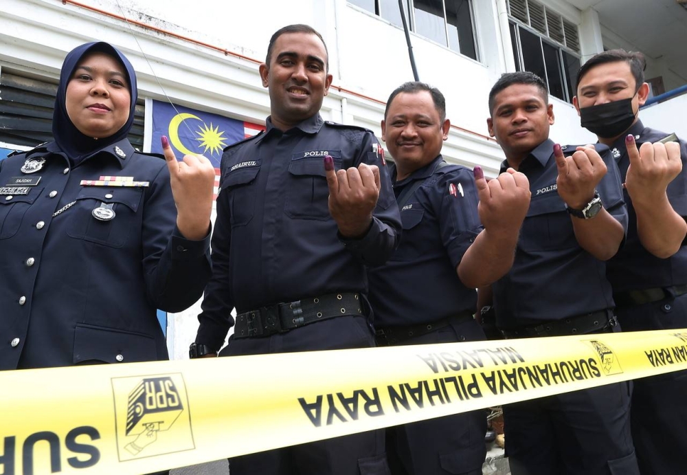 Kulim District Police Headquarters (IPD) personnel showing their fingers that had been dyed with permanent ink on the day of early voting in conjunction with the 15th General Election (GE15) for Parliament P.017 Padang Serai, in Kulim, December 3, 2022. — Bernama pic