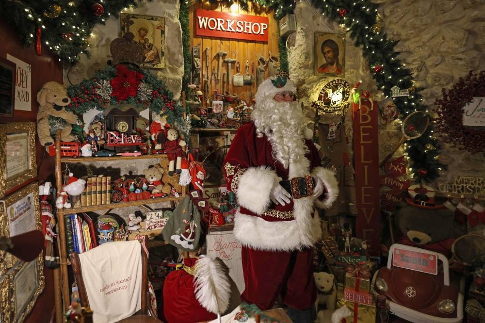 Palestinian Issa Kassissieh, dressed as Santa Claus, poses for a picture at a floor of his home which he turned into Santa's House, in Jerusalem's Old City, a few weeks before the upcoming holiday of Christmas, on November 30, 2022. — AFP pic