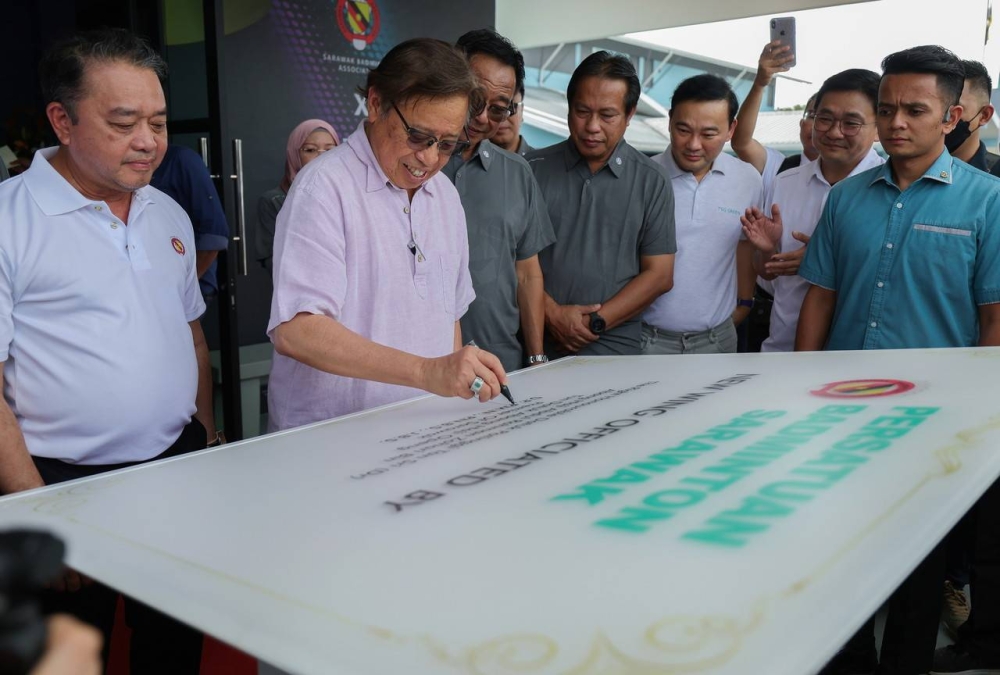 Sarawak Premier Tan Sri Abang Johari Openg (second left) signing the inauguration plaque of the Sarawak Badminton Association Hall and the 2022 Abang Jo Cup Championship December 4, 2022. — Bernama pic