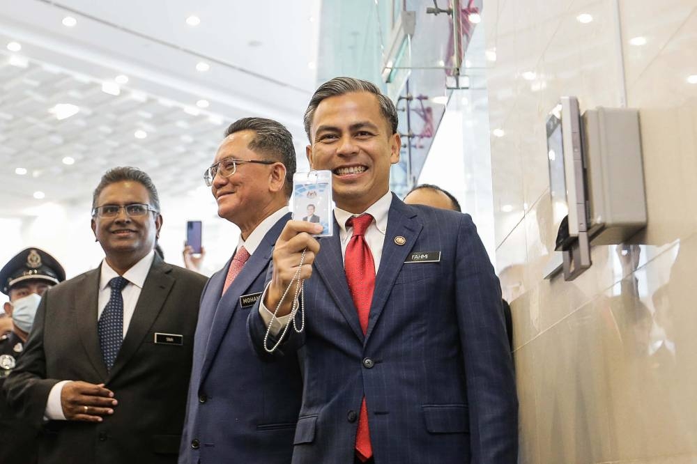 Minister of Digital Communications Ahmad Fahmi Mohamed Fadzil holds up his security card during his first day as the minister at the Ministry of Digital Communications, Putrajaya. — Picture by Sayuti Zainudin