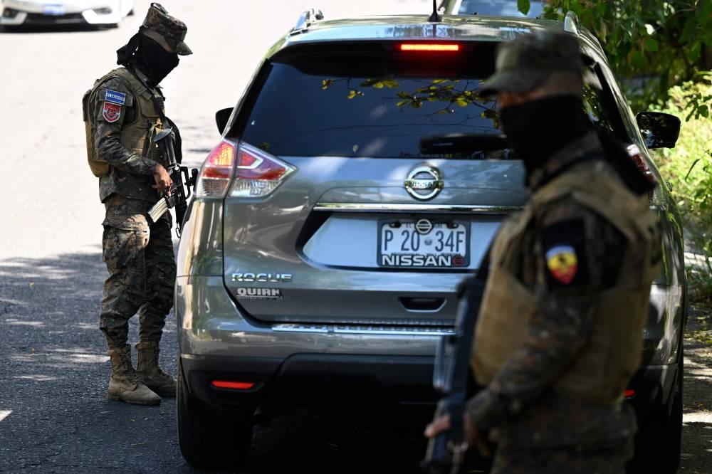 Soldiers stop vehicles at a astreet checkpoint during an operation against gang members in Las Margaritas, a community historically controlled by the MS-13 gang, in Soyapango, El Salvador, on December 4, 2022. — AFP pic