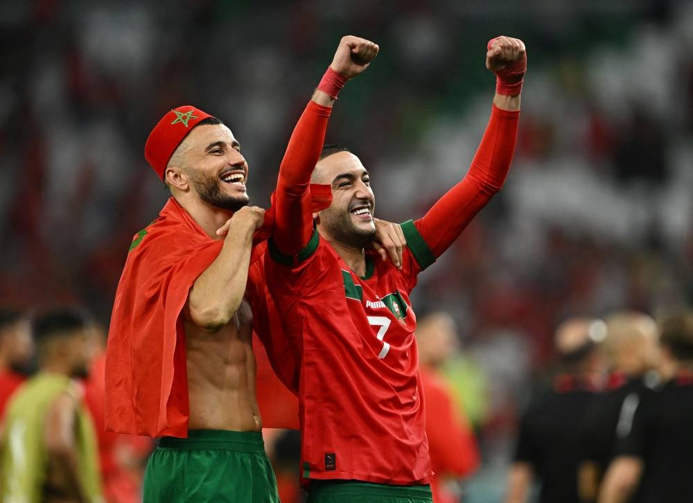 Hakim Ziyech celebrates with Romain Saiss after the penalty shootout as Morocco progress to the quarter finals, December 6, 2022. ― Reuters pic