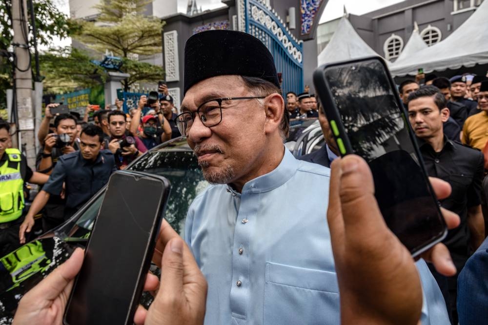 Prime Minister Datuk Seri Anwar Ibrahim greets the crowd as he leaves the Kampung Baru Jamek Mosque in Kuala Lumpur December 9, 2022. ―  Picture by Firdaus Latif