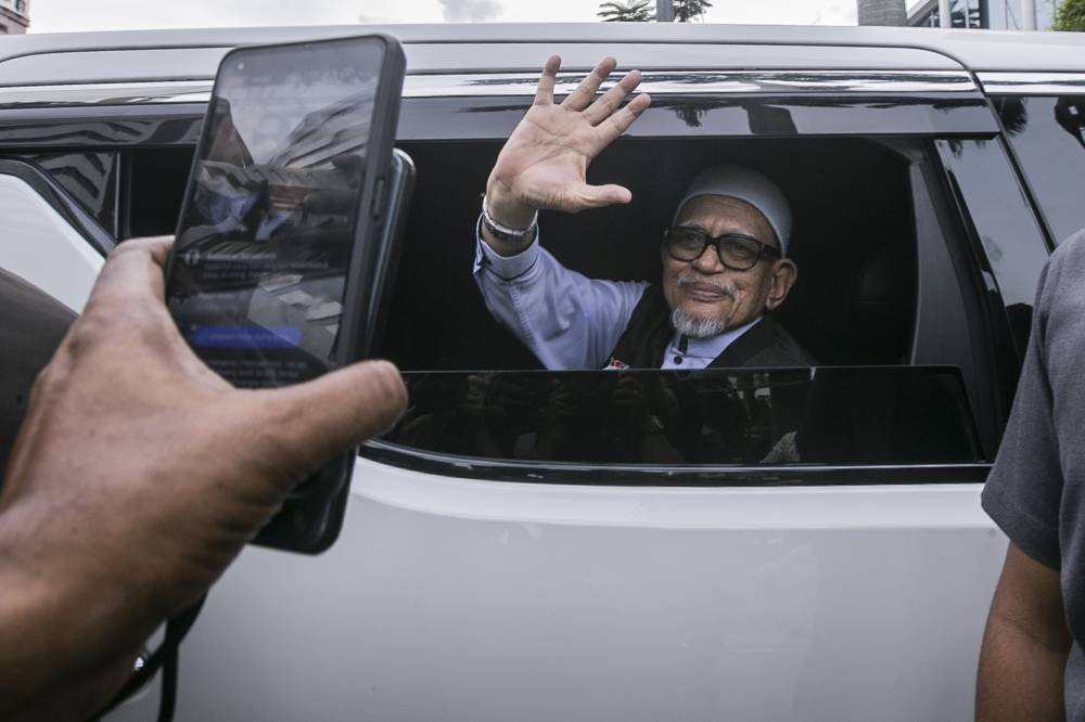 PAS president Tan Sri Abdul Hadi Awang waves at reporters as he leaves IPD Sentul, Kuala Lumpur December 5, 2022. ― Picture by Hari Anggara