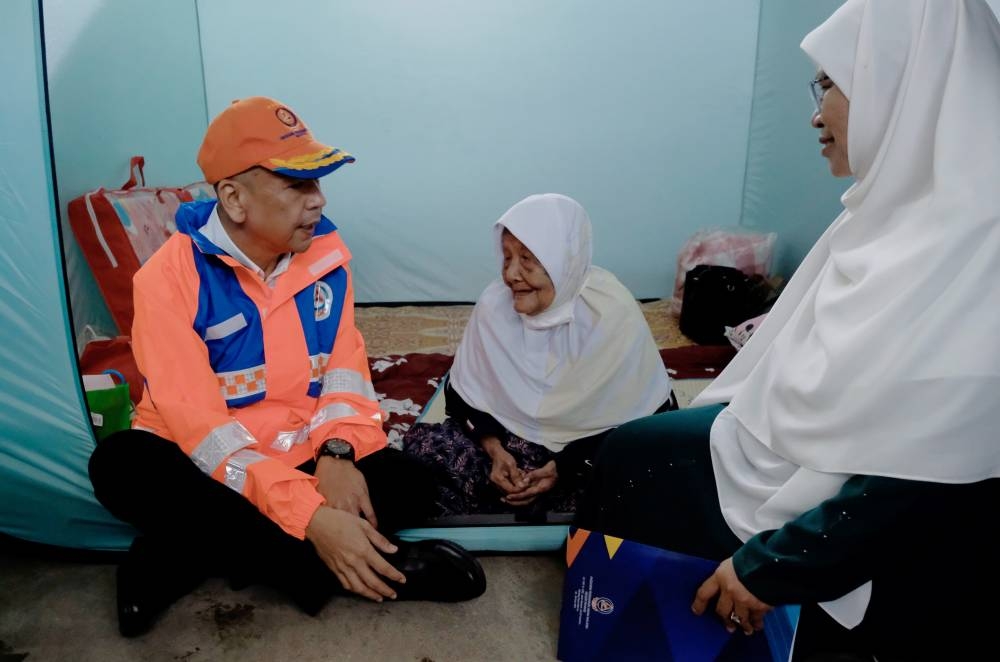 Minister in the Prime Minister’s Department (Sabah, Sarawak Affairs and Special Functions) Datuk Armizan Mohd Ali (right) speaks to flood victims during an inspection of the temporary relief centre at Sekolah Menengah Kebangsaan (SMK) Seri Semantan in Temerloh December 13, 2022. — Bernama pic