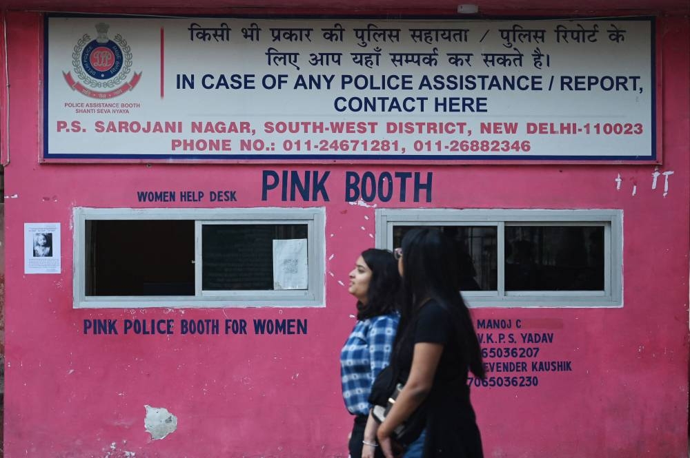 Women walk past outside a Pink booth (police booth made specially for women) at a market in New Delhi December 8, 2022. — AFP pic