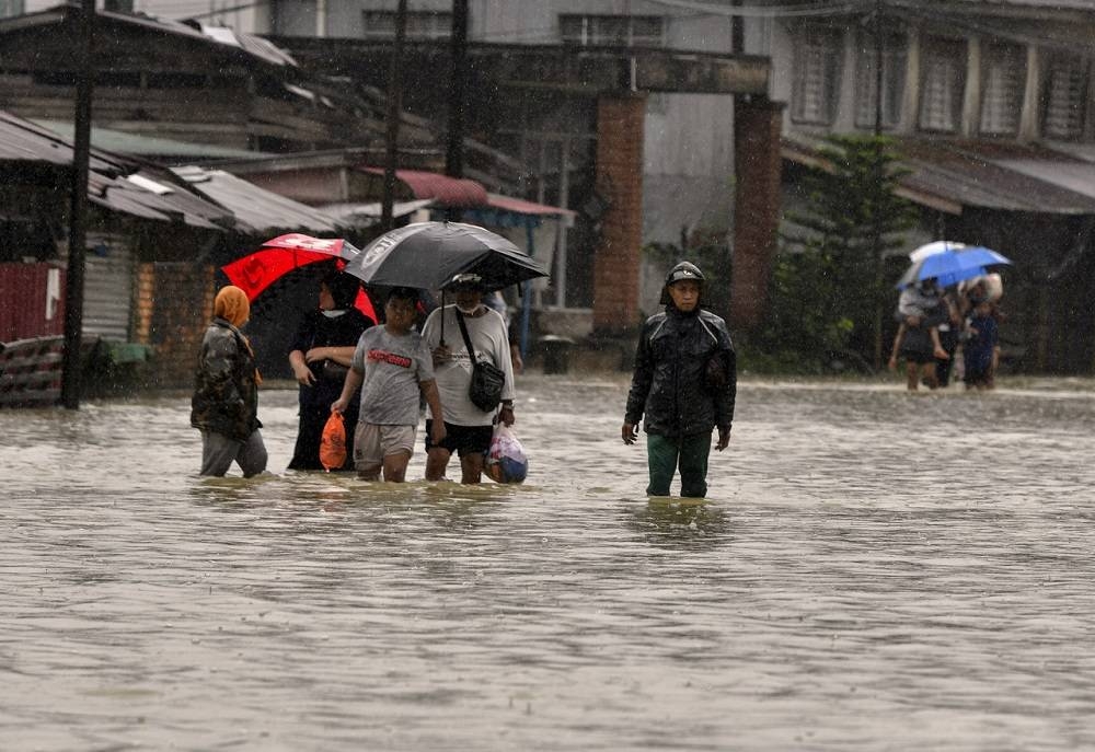 Residents wade through flood waters in Pasir Mas, Kelantan during the monsoon season in 2020. ― Bernama pic