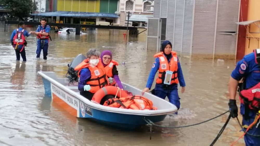 Jami’yah KL and Selangor’s head volunteer Karimah Koh Siow Ken and another volunteer being saved by boat during last April’s flood. — Picture courtesy of Jam’iyah KL and Selangor