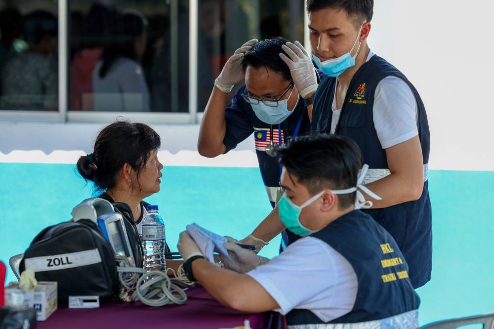 HKL staff check on a landslide victim at the Hulu Yam Baru police station in Hulu Selangor December 16, 2022. — Bernama pic