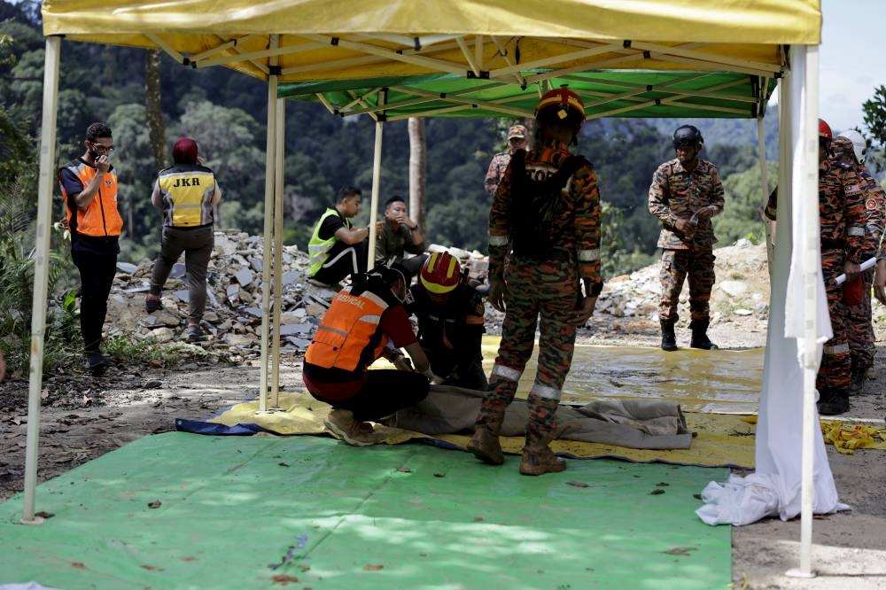 Search and rescue personnel recover the body of a deceased victim following a landslide near the campsite of Father's Organic Farm in Batang Kali December 16, 2022. — Reuters pic