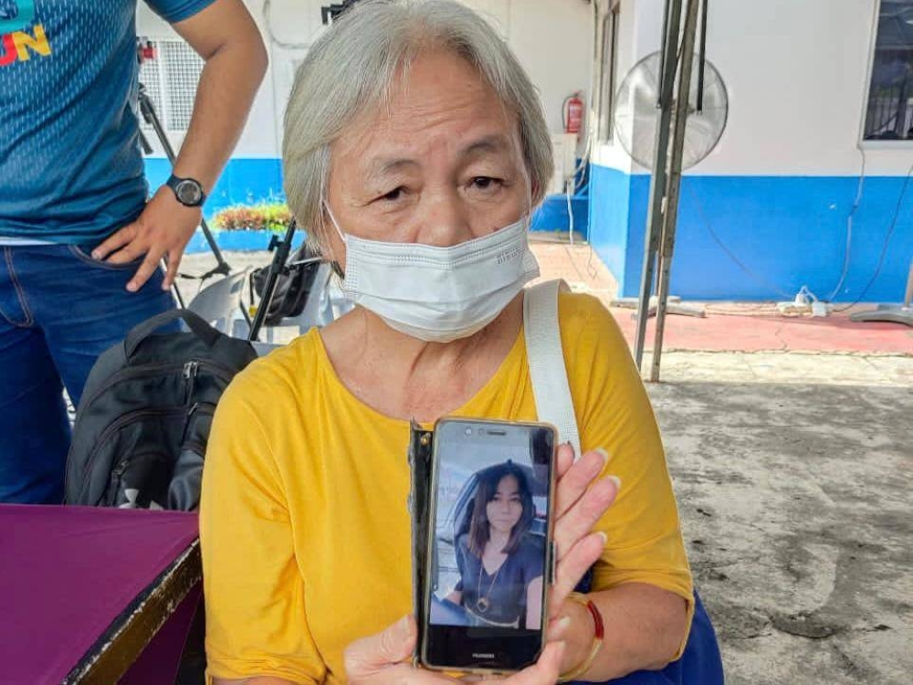 Tan Ah Choe, 66, shows a picture of her missing daughter, teacher Hong Mei Jing, 38, to reporters at the Hulu Yam Baru district police station, December 16, 2022 — Picture by Zarrah Morden 