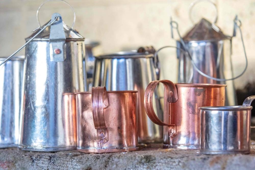 A photograph taken on November 23, 2022 shows tin and copper cups and billy cans made by James Collins, one of the two remaining traditional Traveller tinsmiths in Ireland, and displayed in his workshop in Finglas, Dublin. — AFP pic
