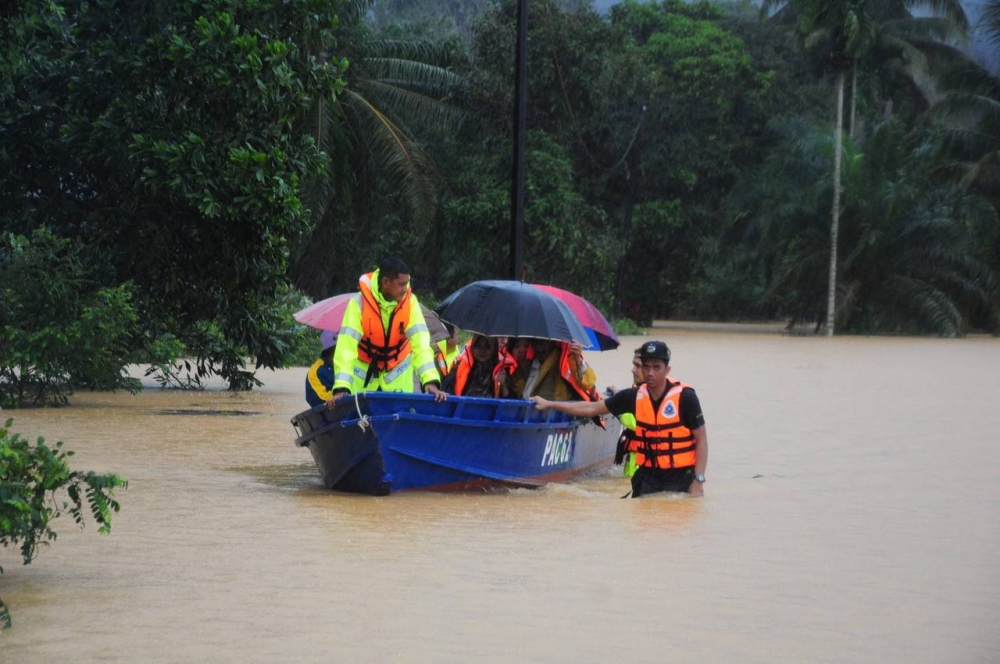 Members of the rescue team consisting of policemen from the Pasir Akar Police Station evacuating flood victims in Kampung Baroh Masin, Pasir Akar, Hulu Besut by using a boat, December 17, 2022. — Bernama pic