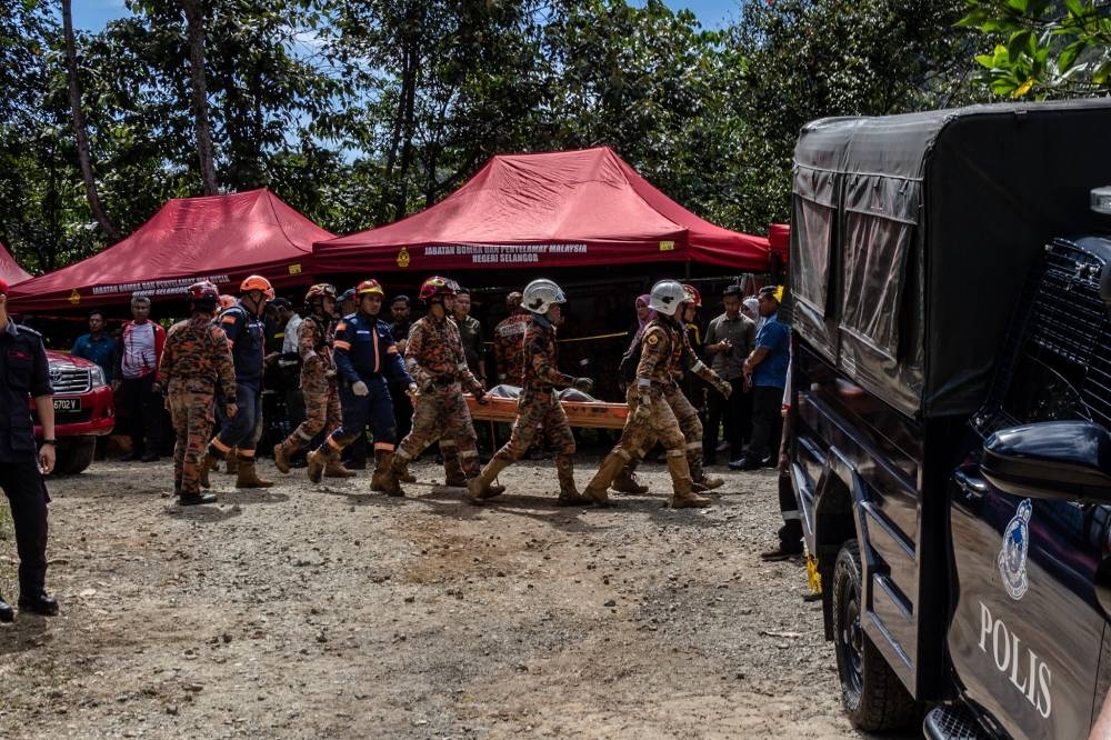 Search and rescue personnel lifting one of the bodies recovered from the landslide at Batang Kali, December 16, 2022. — Picture by Firdaus Latif