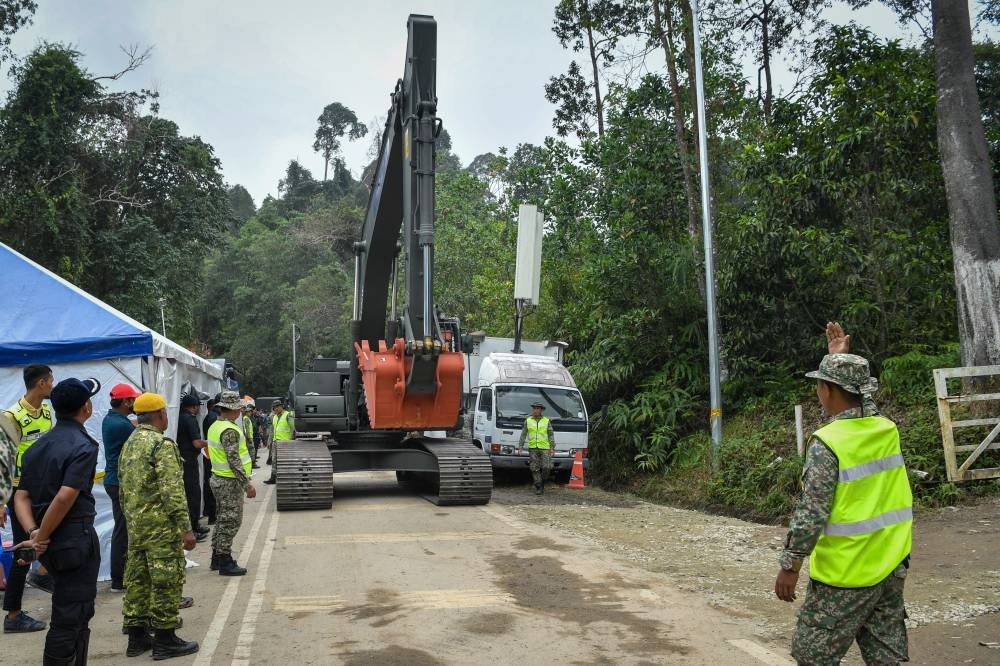 Armed Forces personnel direct an excavator onto the grounds of the Father's Organic Farm campsite in Batang Kali December 19, 2022. — Bernama pic 