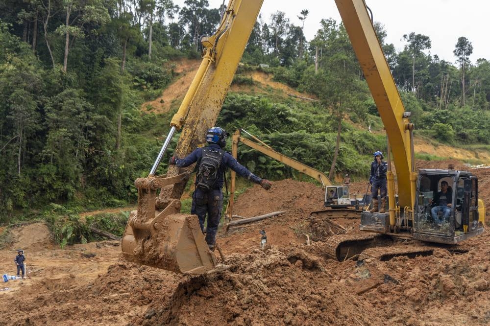 Rescue personnel work at the site of a landslide at the Father's Organic Farm campsite in Batang Kali, December 19, 2022. — Picture by Shafwan Zaidon