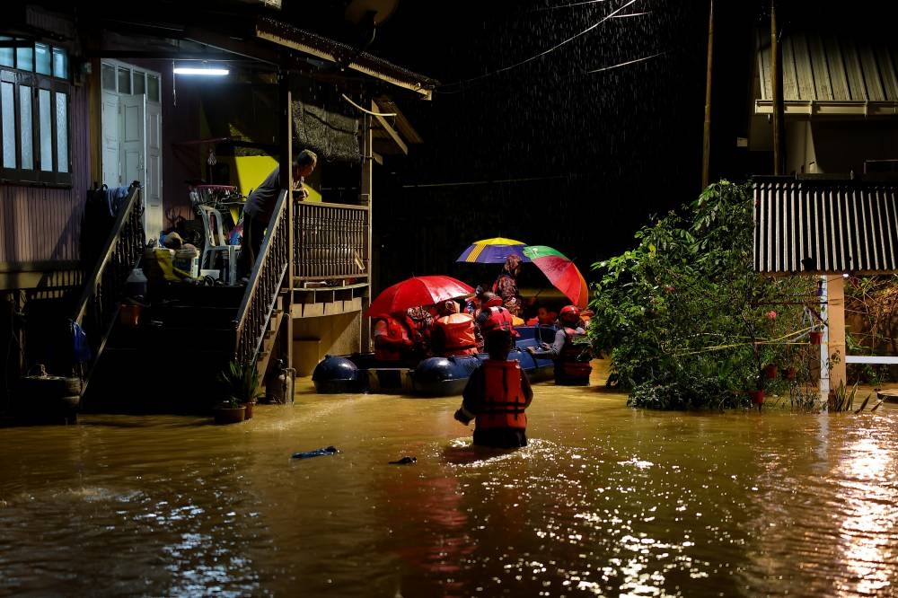 Terengganu Fire and Rescue Department personnel help evacuate flood victims at Kampung Pulau Rusa Hulu in Kuala Terengganu December 19, 2022. — Bernama pic