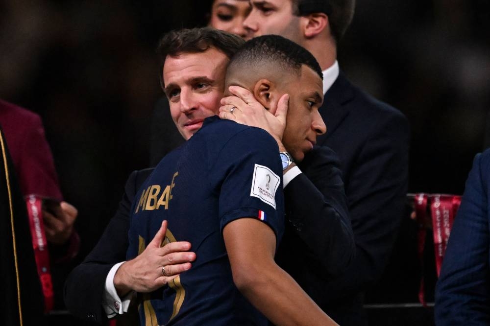 France's forward #10 Kylian Mbappe is consoled by French President Emmanuel Macron (left) during the trophy ceremony after France lost the Qatar 2022 World Cup final football match between Argentina and France at Lusail Stadium in Lusail, north of Doha on December 18, 2022. — AFP pic