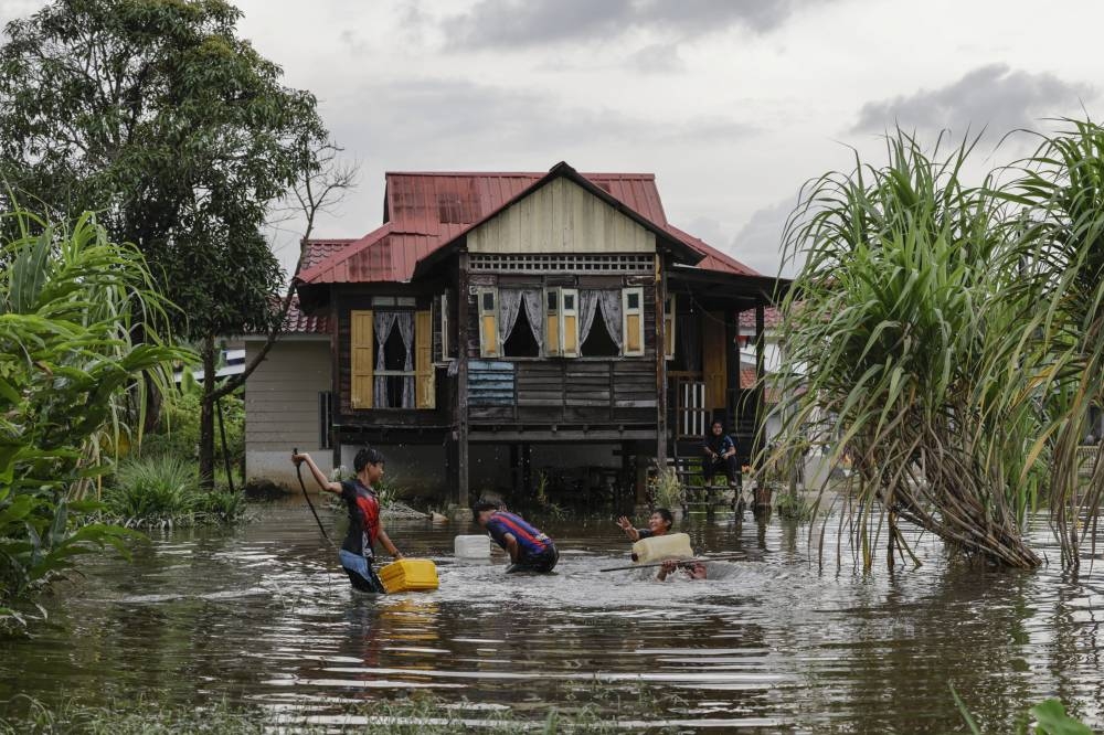 Children play in flood waters in Klang, November 12, 2022. The Irrigation and Drainage Department (JPS) has forecast that floods will hit Sungai Melikai and its surrounding areas in the Mersing district starting at 4am tomorrow. — Bernama pic