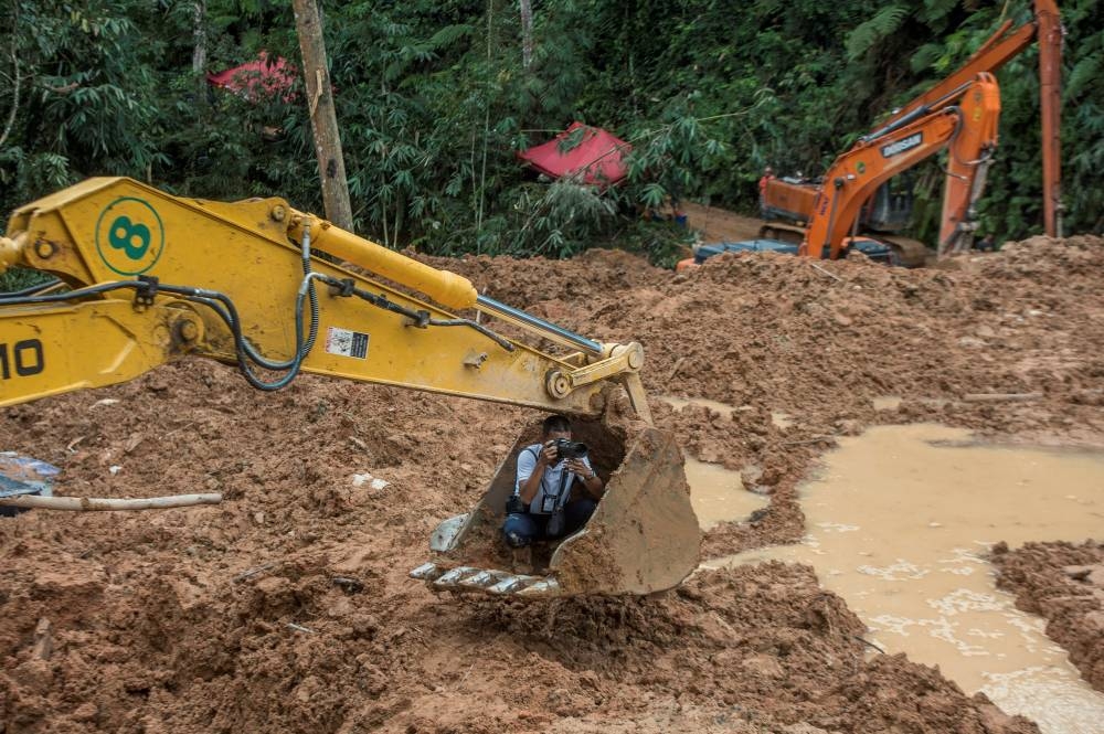 An excavator being used to help media members carry out their jobs. — Picture by Shafwan Zaidon