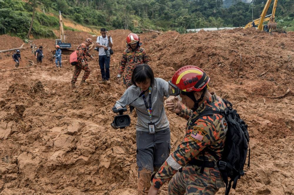 Media members being helped by security personnnel to go over to the Red Zone. — Picture by Shafwan Zaidon