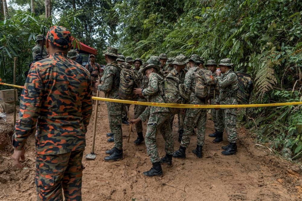 Army personnel getting ready for duty at a nearby stream. — Picture by Shafwan Zaidon