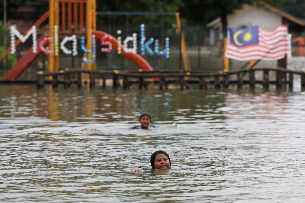 Children are seen playing in floodwaters in Jajahan Pasir Mas December 21, 2022. — Bernama pic