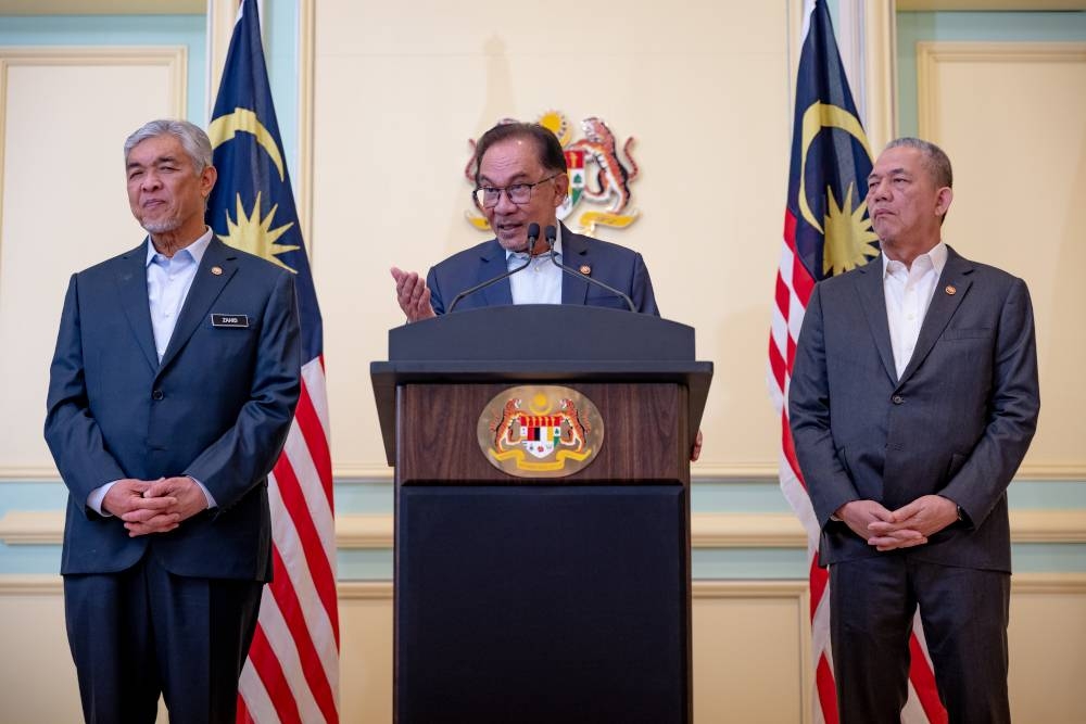 Prime Minister Datuk Seri Anwar Ibrahim flanked by Deputy Prime Ministers Datuk Seri Ahmad Zahid Hamidi and Datuk Seri Fadillah Yusof after a Cabinet meeting in Putrajaya December 21, 2022. With regards to MA63, Anwar said the progress report will be made known in January. — Picture courtesy of the Prime Minister’s Office