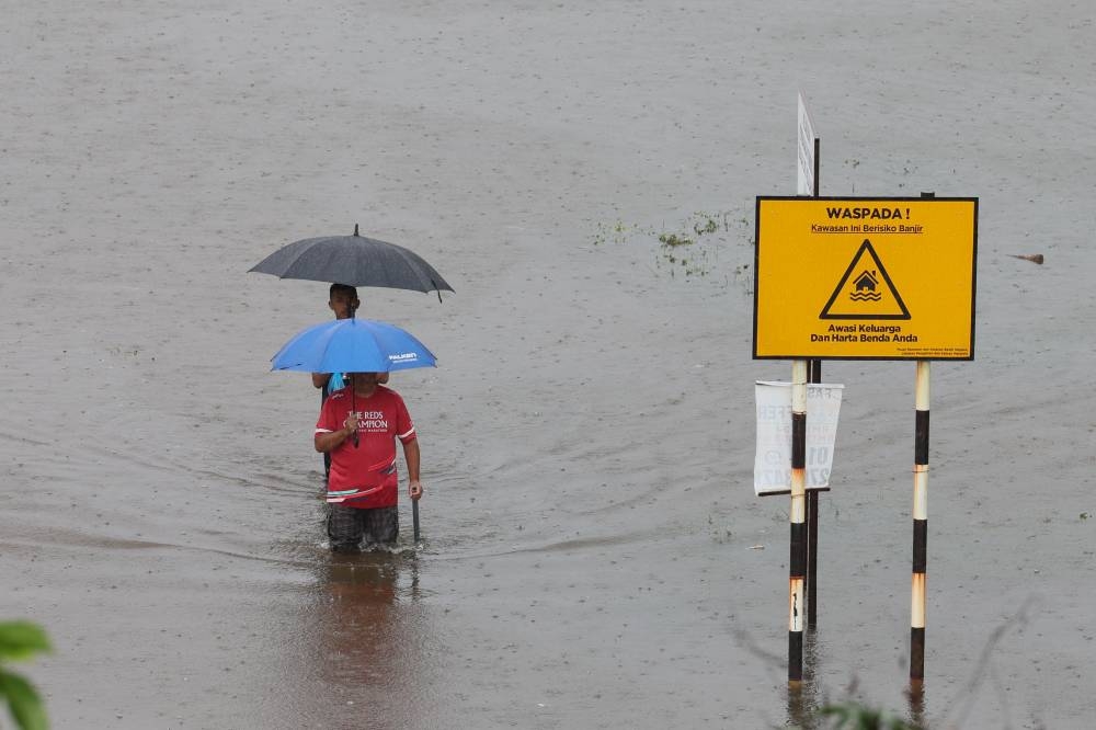 Residents of Taman Desa Tanjung Damai, Gong Badak in Terengganu wade through the flood to get to the temporary relief centre, December 21, 2022. — Bernama pic 